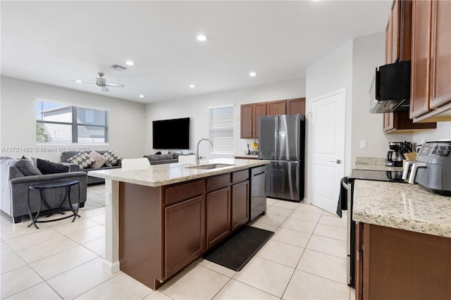 kitchen featuring sink, ceiling fan, an island with sink, light tile patterned flooring, and stainless steel appliances