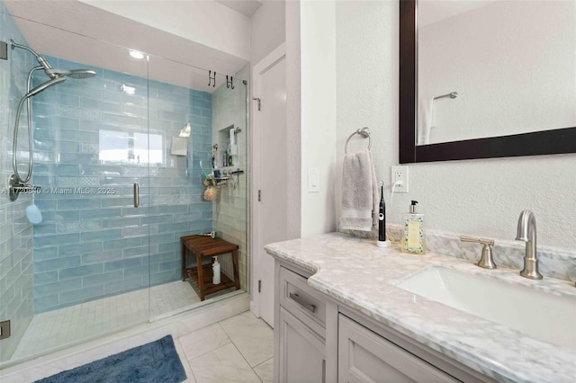 bathroom featuring marble finish floor, vanity, and a stall shower