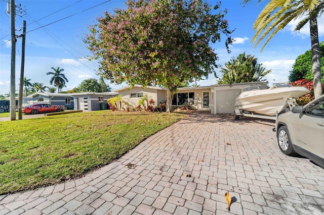 ranch-style home with driveway and a front yard