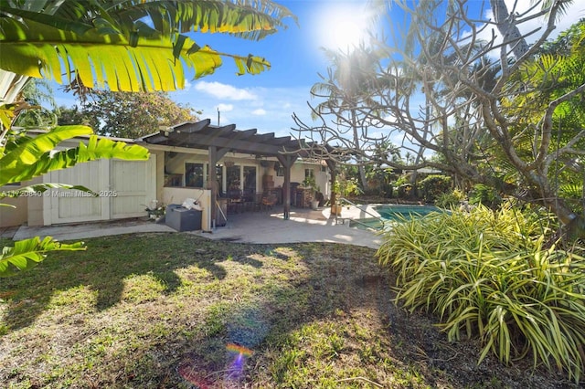 rear view of house featuring a pergola, fence, a patio area, an outdoor pool, and stucco siding