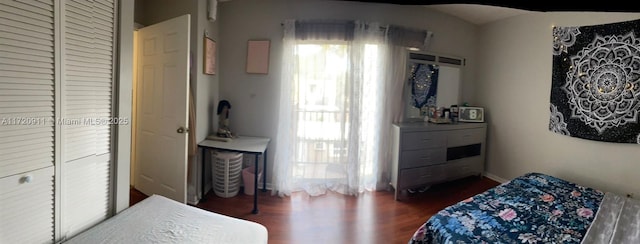 bedroom with dark wood-type flooring and a closet