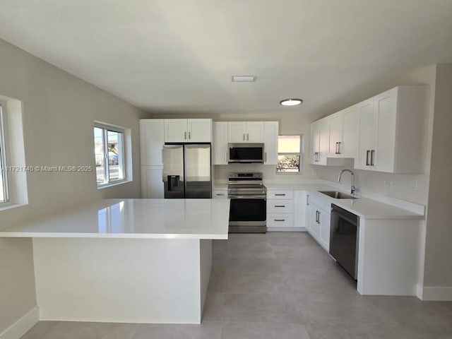 kitchen featuring white cabinets, appliances with stainless steel finishes, light tile patterned flooring, and sink