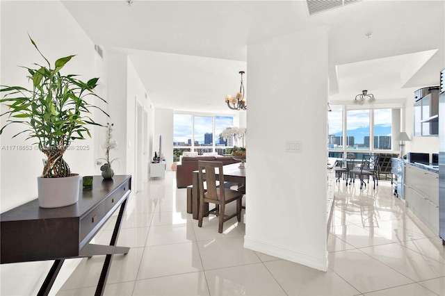 hall featuring floor to ceiling windows, plenty of natural light, light tile patterned flooring, and a chandelier