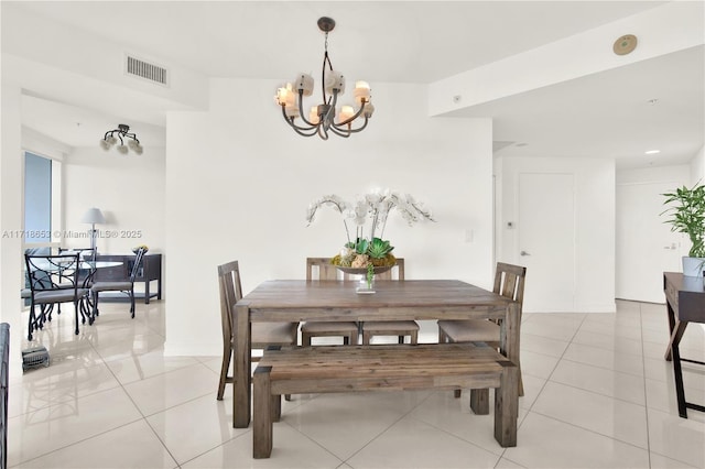 tiled dining space featuring a notable chandelier