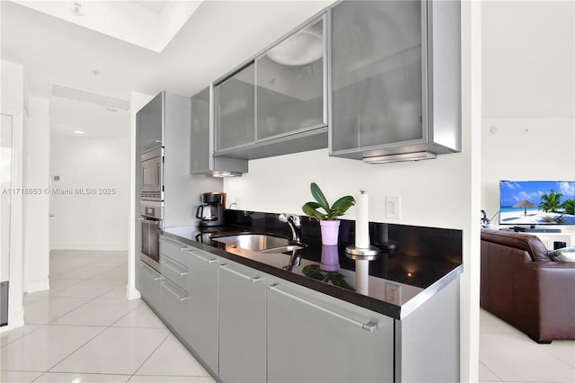 kitchen featuring gray cabinetry, light tile patterned floors, sink, and appliances with stainless steel finishes