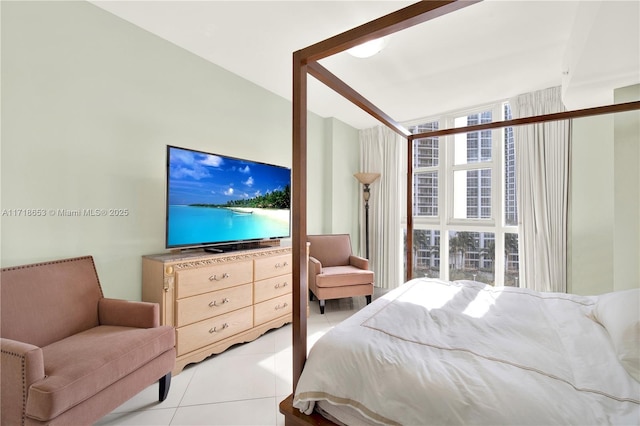 bedroom featuring light tile patterned floors and a wall of windows