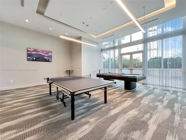 rec room with carpet flooring, a towering ceiling, billiards, and a wall of windows