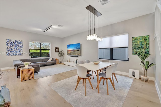 dining room with track lighting and light hardwood / wood-style floors