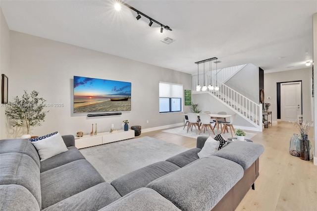 living room with track lighting and light hardwood / wood-style floors