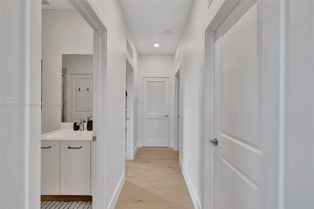 hall with sink and light wood-type flooring