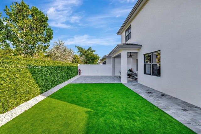 view of yard featuring a patio area and ceiling fan