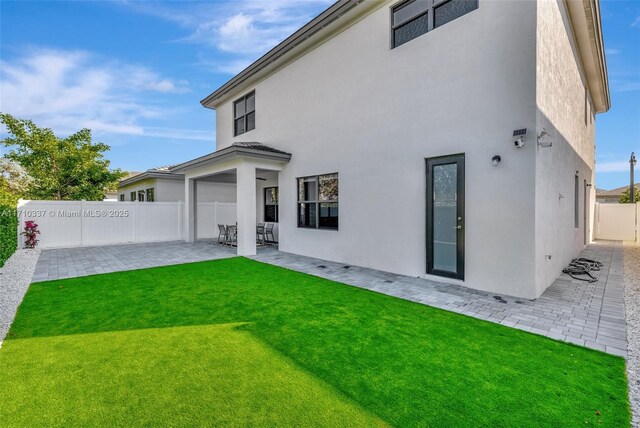 back of house featuring a patio area and a yard