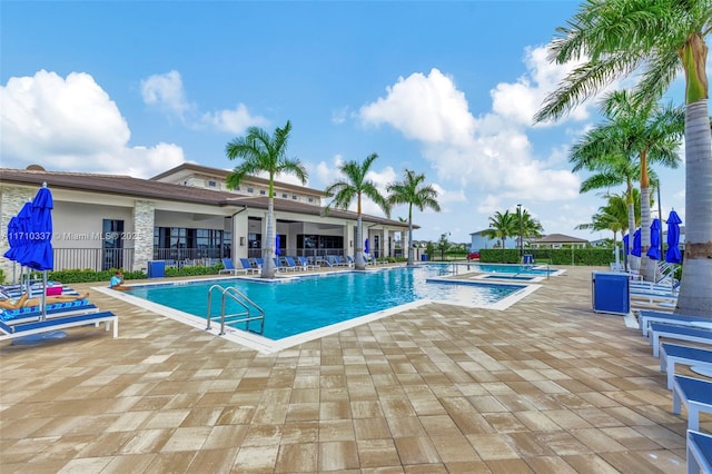 view of swimming pool with a community hot tub and a patio area