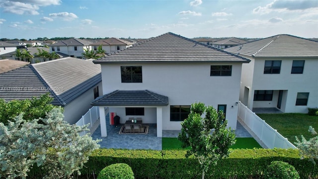 rear view of property with a lawn and a patio