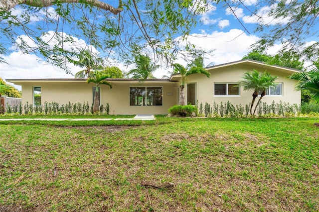 rear view of property with stucco siding and a lawn