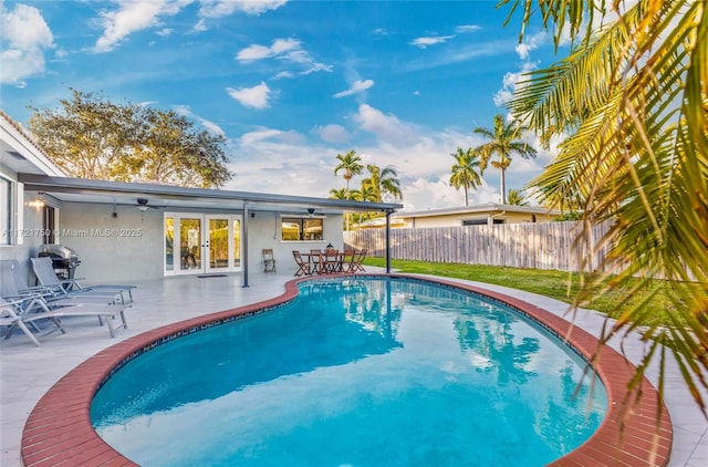 view of swimming pool featuring a patio and french doors