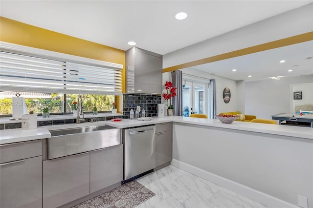 kitchen featuring gray cabinets, stainless steel dishwasher, tasteful backsplash, and sink