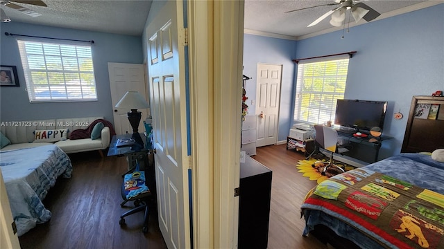 bedroom with multiple windows, dark hardwood / wood-style floors, and ceiling fan