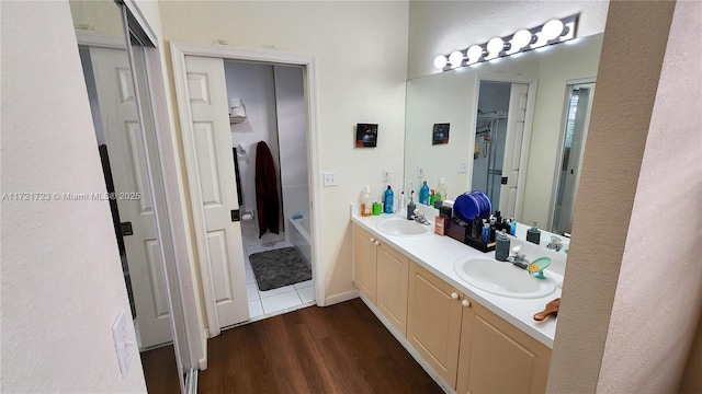 bathroom with a bathtub, vanity, and wood-type flooring