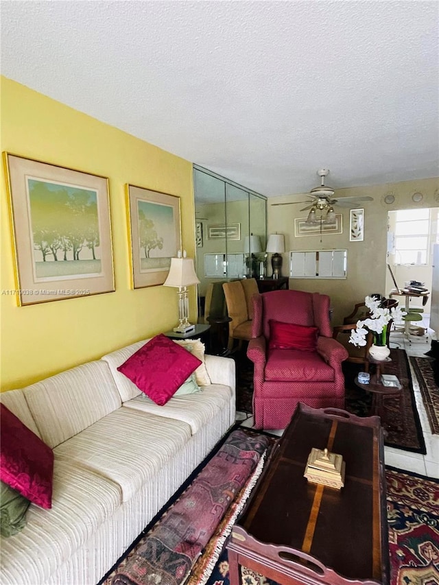 living room with ceiling fan and a textured ceiling