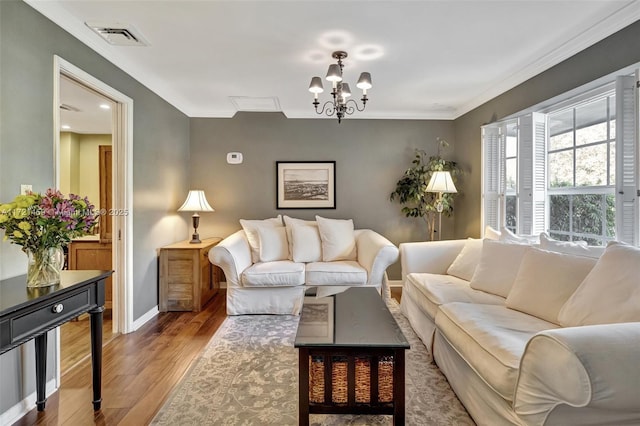 living room with a chandelier, hardwood / wood-style flooring, and ornamental molding