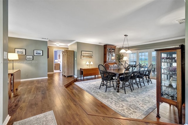 dining room featuring crown molding and dark hardwood / wood-style flooring