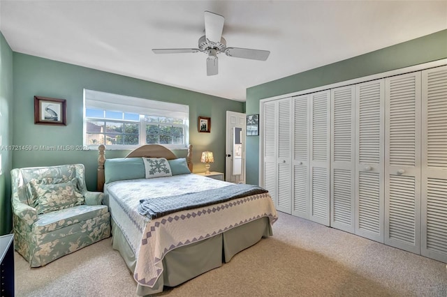 bedroom with ceiling fan, a closet, and light colored carpet