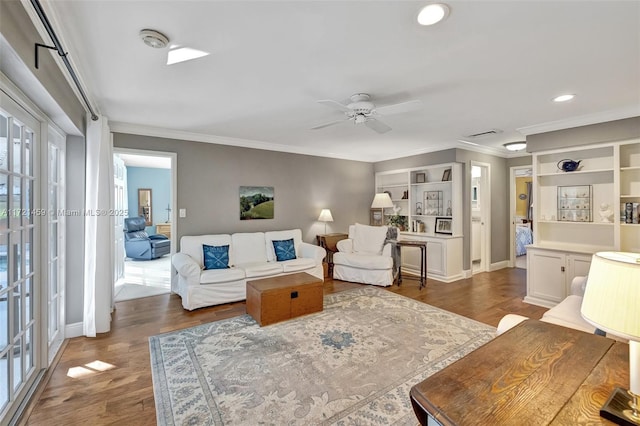 living room with hardwood / wood-style floors, ceiling fan, and crown molding