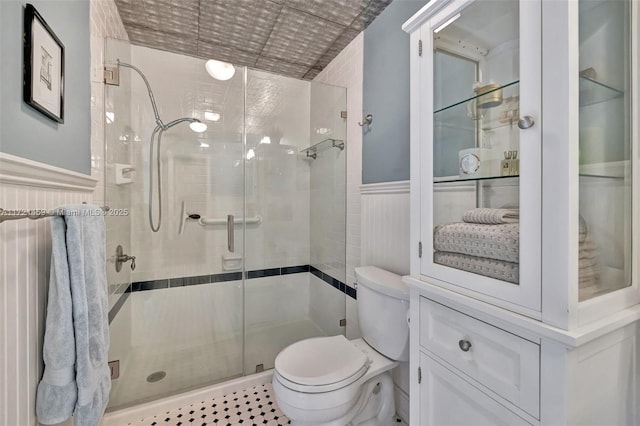 bathroom featuring toilet and a shower with shower door