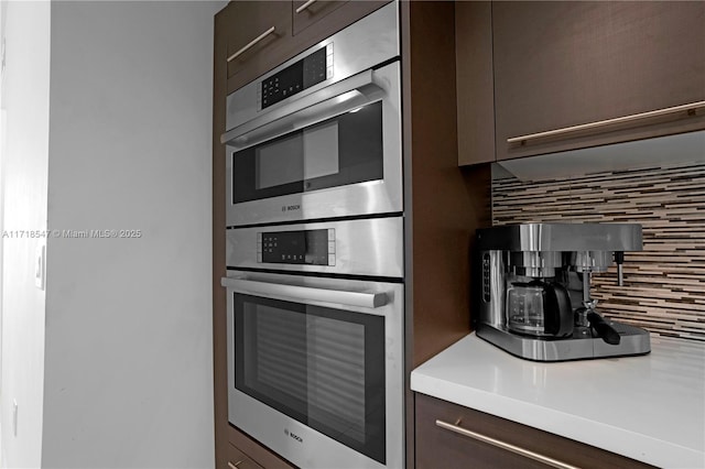 7751 NW 107th Ave Unit 509, Doral, FL 33178 - kitchen with backsplash, dark brown cabinets, light countertops, and double oven