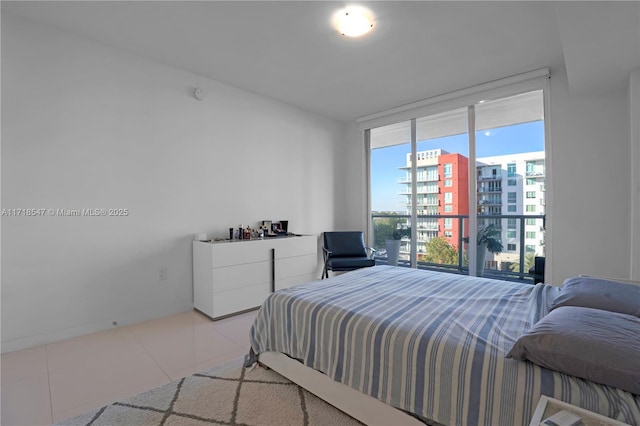 bedroom with light tile patterned floors, a city view, and floor to ceiling windows