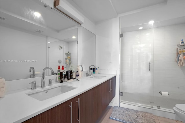 full bath featuring double vanity, tile patterned flooring, a sink, and toilet