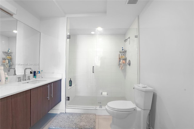 full bathroom featuring a stall shower, vanity, toilet, and tile patterned floors