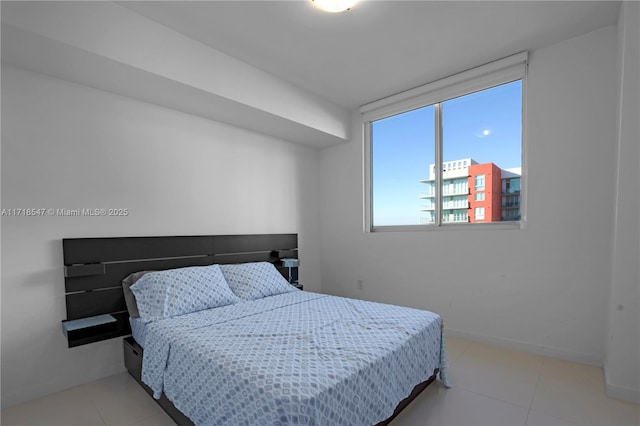 bedroom featuring light tile patterned floors and baseboards