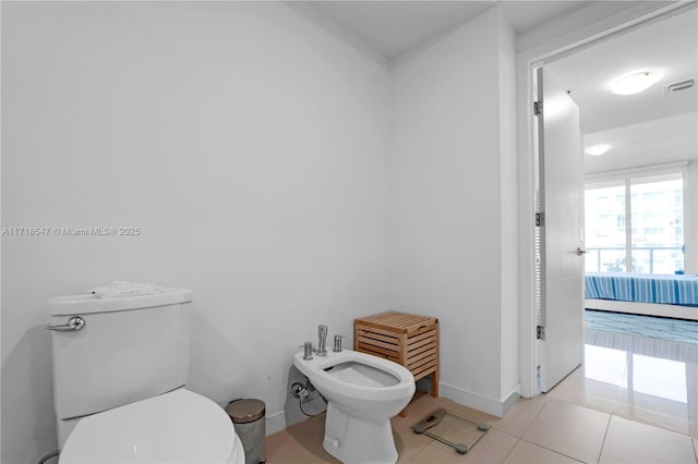 bathroom featuring toilet, visible vents, baseboards, tile patterned floors, and a bidet