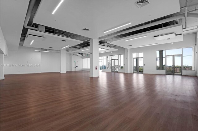 interior space with baseboards, visible vents, and dark wood-type flooring