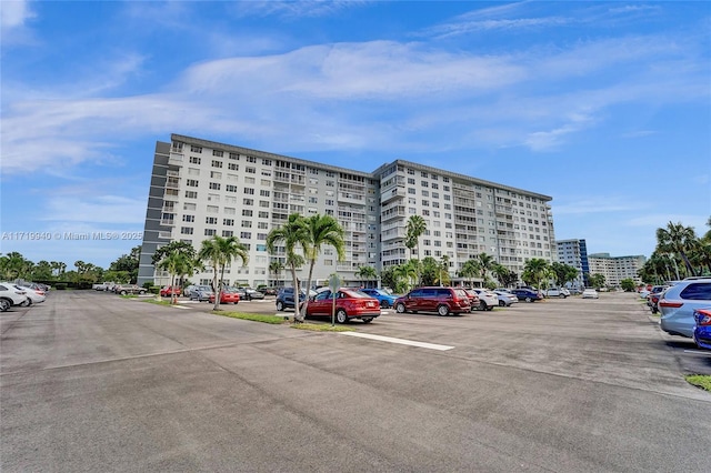 view of building exterior with a view of city and uncovered parking