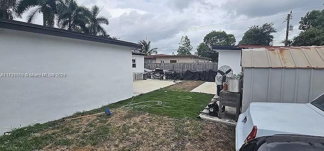 view of yard featuring a storage shed and a patio area