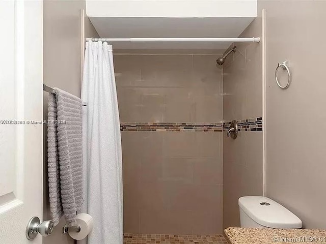 bathroom featuring curtained shower and toilet