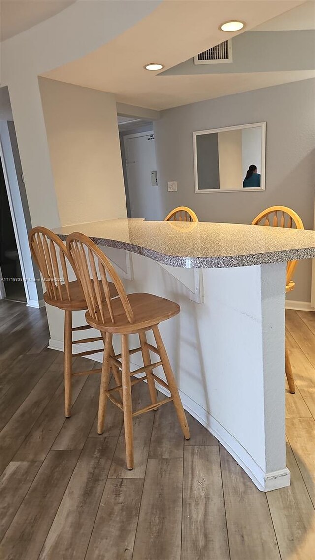 kitchen with dark wood-type flooring and a breakfast bar area