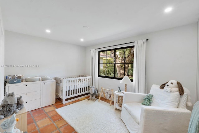 bedroom featuring a crib and light tile patterned floors