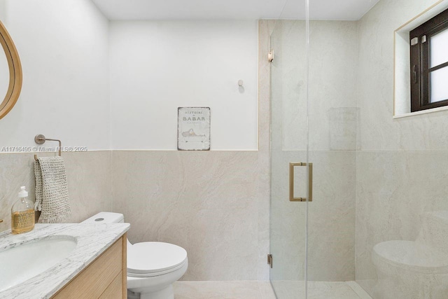 bathroom featuring vanity, toilet, an enclosed shower, and tile walls