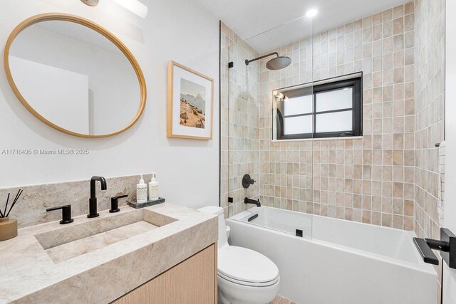 full bathroom with vanity, tiled shower / bath combo, and toilet