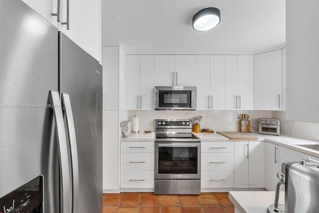 kitchen featuring white cabinetry, tile patterned flooring, tasteful backsplash, and stainless steel appliances