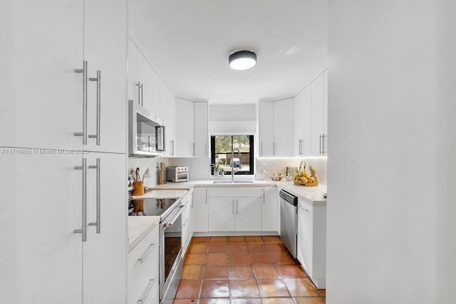 kitchen featuring backsplash, sink, white cabinets, and appliances with stainless steel finishes