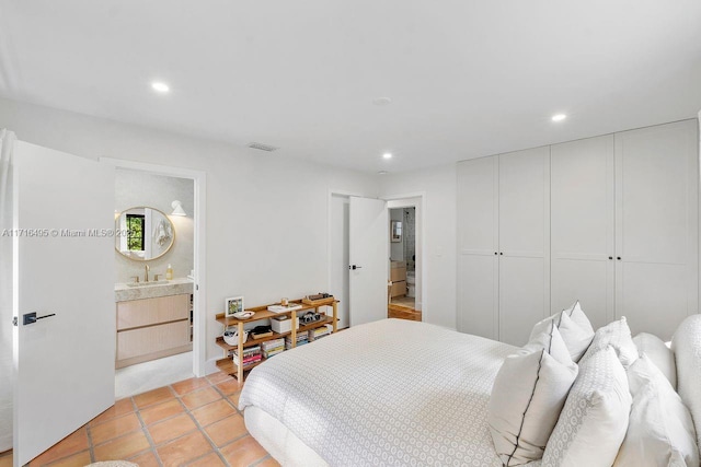 tiled bedroom featuring sink, a closet, and ensuite bathroom