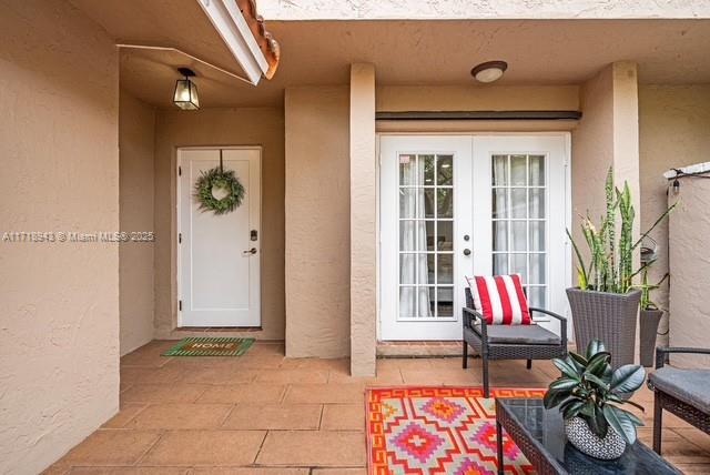 doorway to property with a patio area and french doors