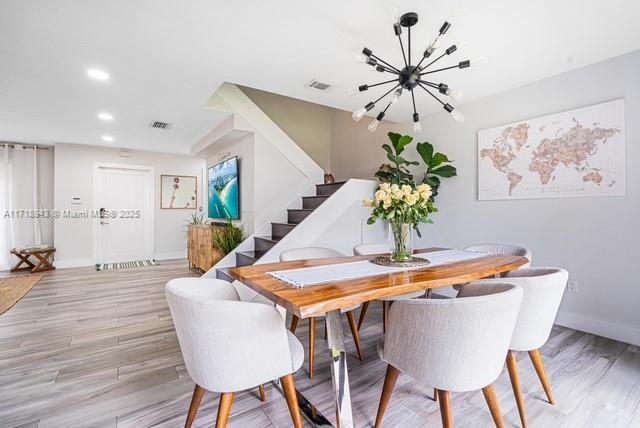 dining room featuring an inviting chandelier and light hardwood / wood-style flooring