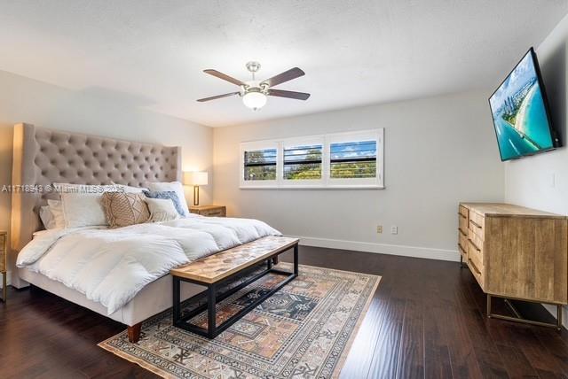 bedroom with ceiling fan and dark wood-type flooring