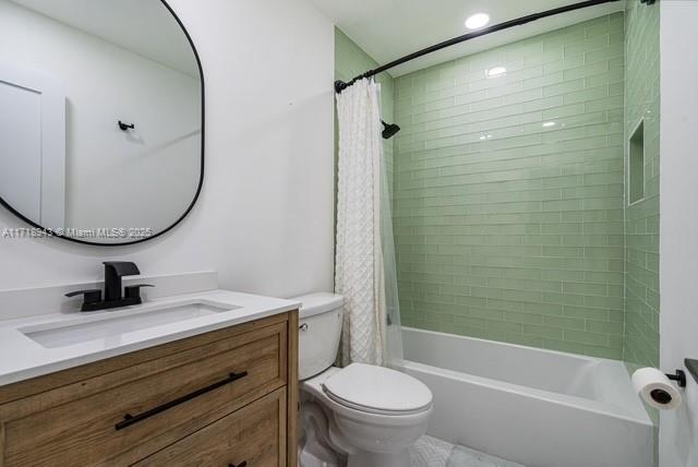 full bathroom with shower / bath combo with shower curtain, vanity, and toilet